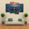 A young couple share a romantic dinner with candles heart on the sea sand beach multi panel canvas wall art