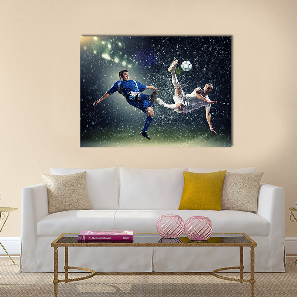 Two football players in jump to strike the ball at the stadium under rain Multi panel canvas wall art