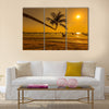 Sunset with palm and longtail boats on tropical beach. multi panel canvas wall art