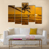 Sunset with palm and longtail boats on tropical beach. multi panel canvas wall art