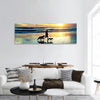 Man with a dogs running on the beach at sunset Bali island, panoramic canvas wall art