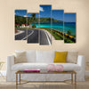 Asphalt road along tropical coastline with palm trees and buildings on a side multi panel canvas wall art