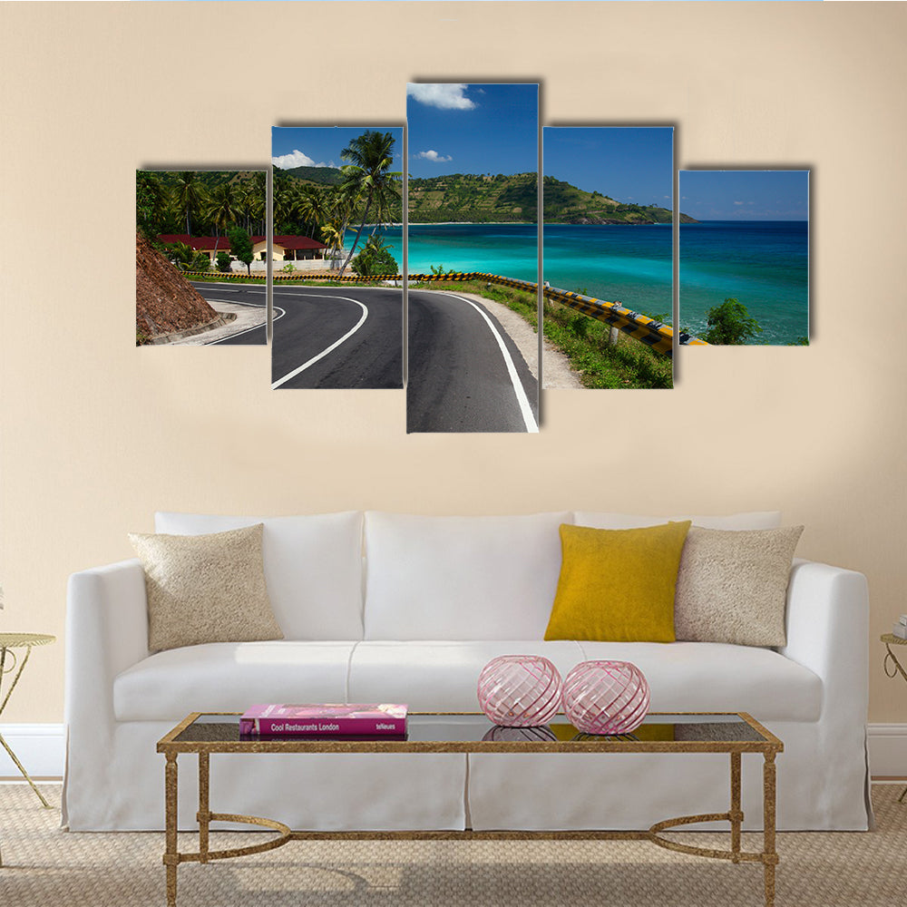 Asphalt road along tropical coastline with palm trees and buildings on a side multi panel canvas wall art