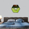 Golf ball on tee in front of driver hexagonal canvas wall art