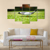 Golf ball on tee in front of driver Multi Panel Canvas Wall Art