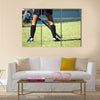 The strong white legs of a sportive young woman playing Hockey sport Multi panel canvas wall art