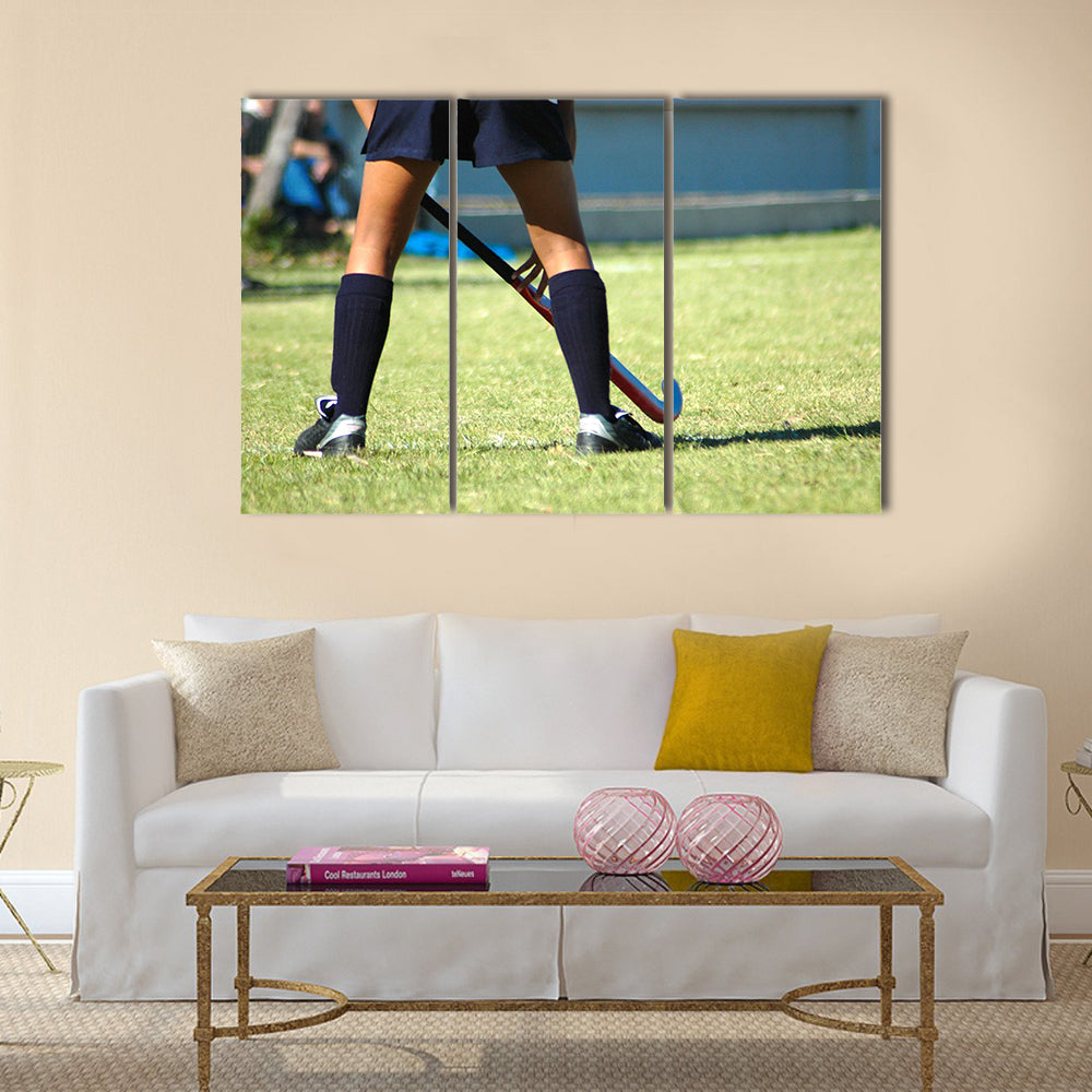 The strong white legs of a sportive young woman playing Hockey sport Multi panel canvas wall art