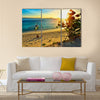 Young happy couple enjoying a beautiful sunset multi panel canvas wall art