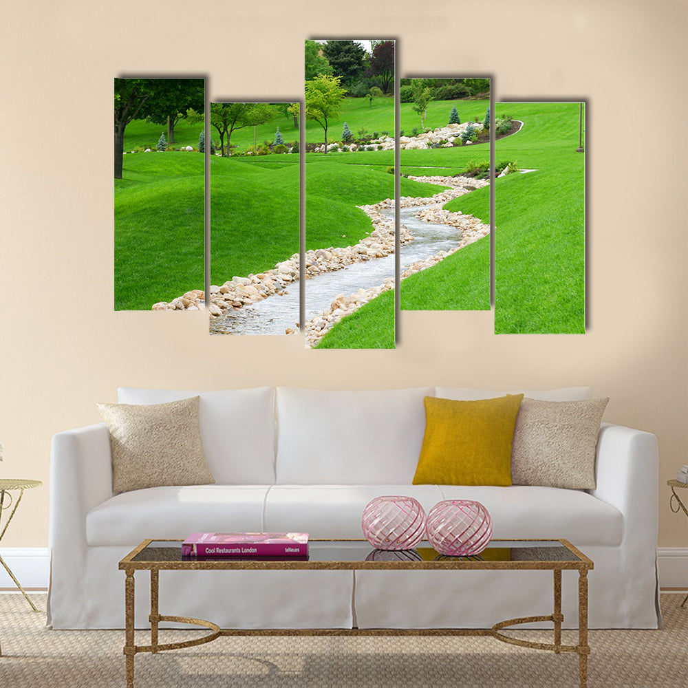 Stream of water flowing through grassy hills with trees Multi Panel Canvas Wall Art