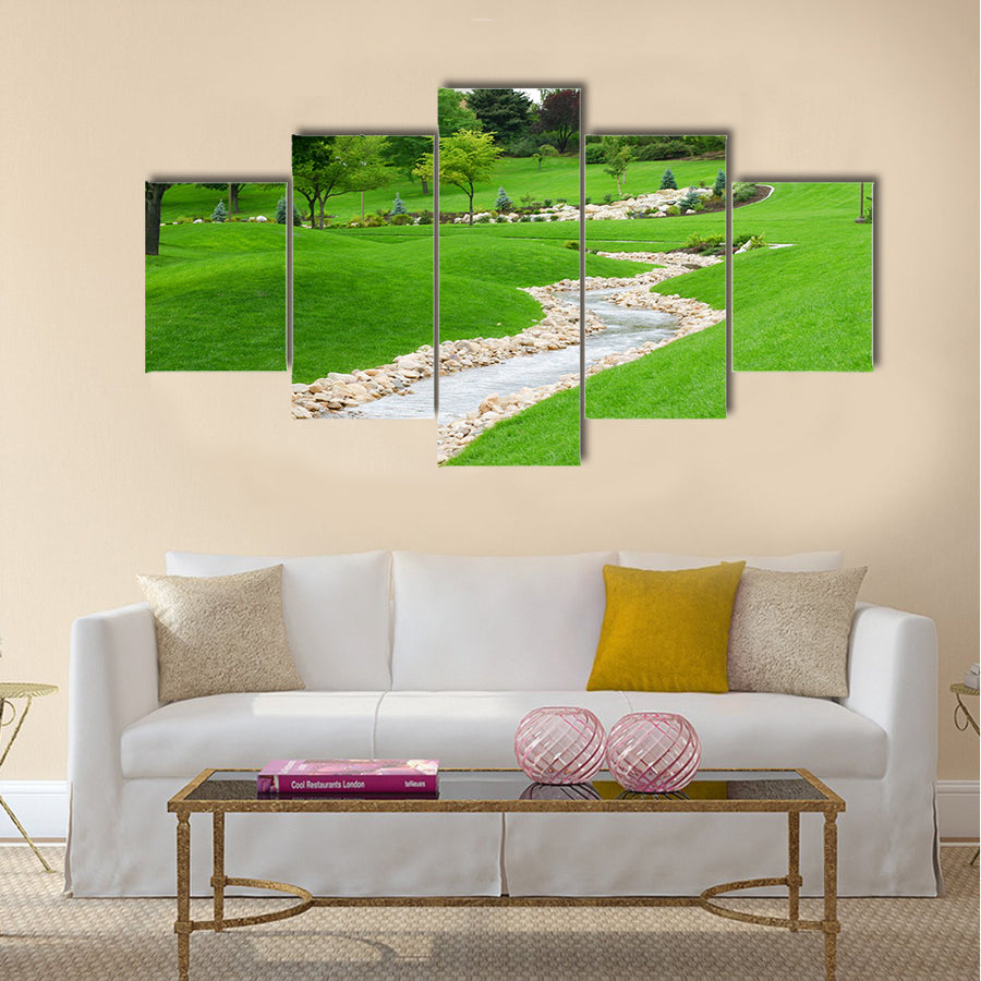 Stream of water flowing through grassy hills with trees Multi Panel Canvas Wall Art