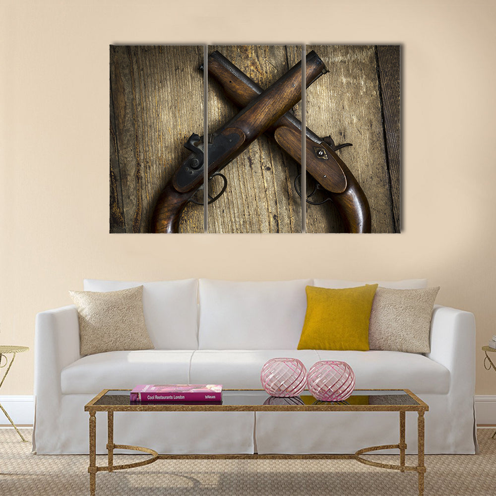 Two vintage pistols on wooden background multi panel canvas wall art