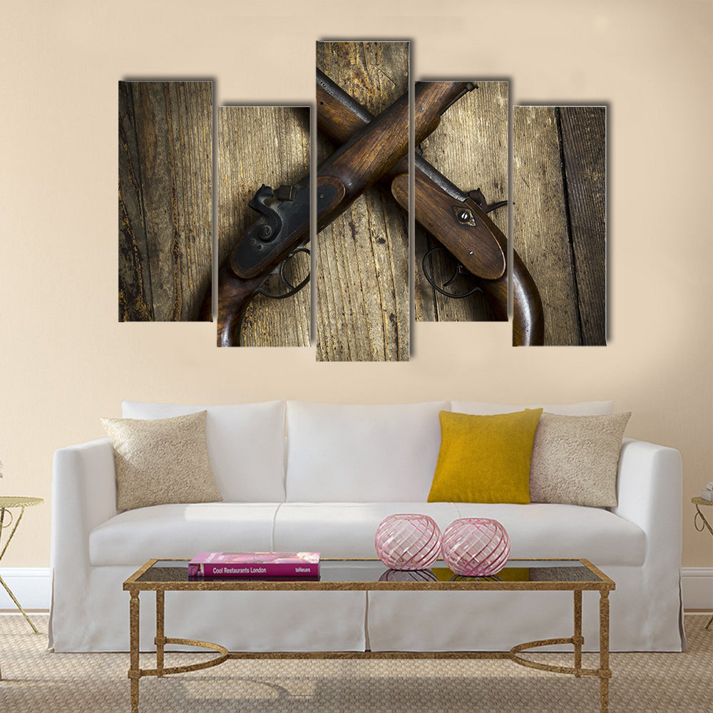 Two vintage pistols on wooden background multi panel canvas wall art