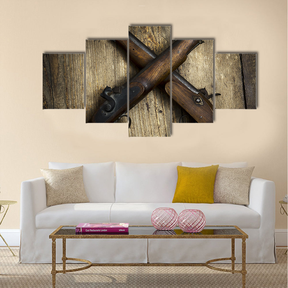 Two vintage pistols on wooden background multi panel canvas wall art