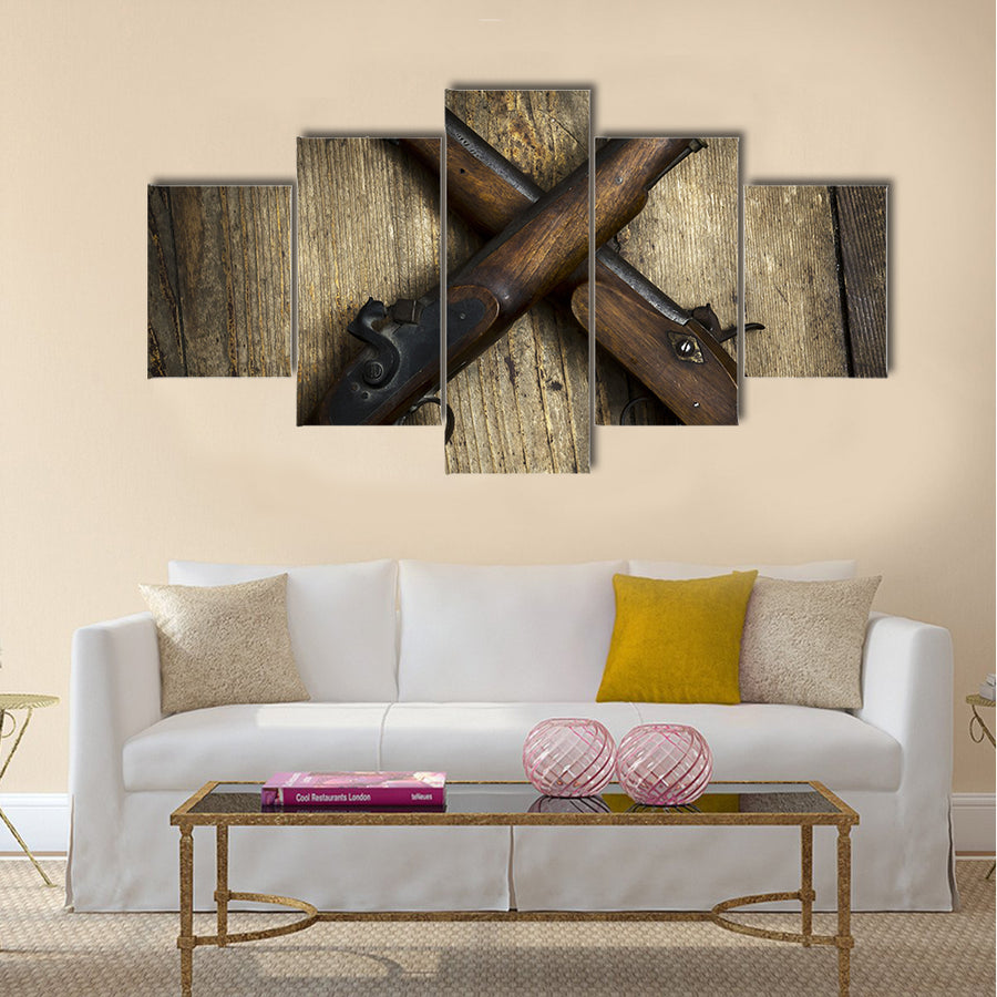 Two vintage pistols on wooden background multi panel canvas wall art