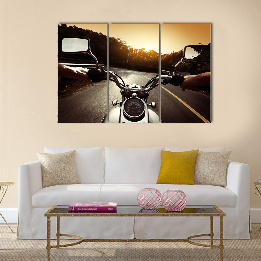 Driver riding motorcycle on an asphalt road through forest Multi panel canvas wall art