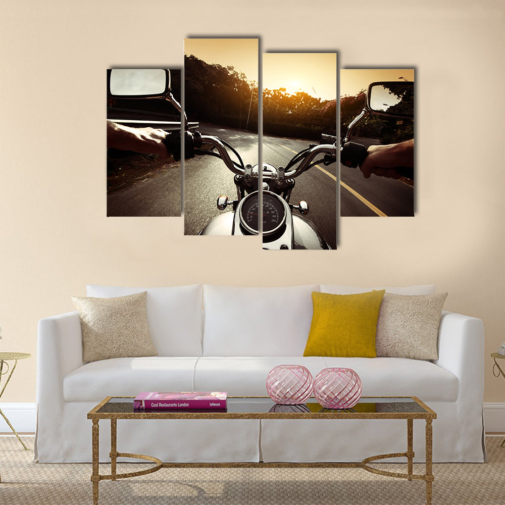 Driver riding motorcycle on an asphalt road through forest Multi panel canvas wall art
