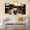 Driver riding motorcycle on an asphalt road through forest Multi panel canvas wall art