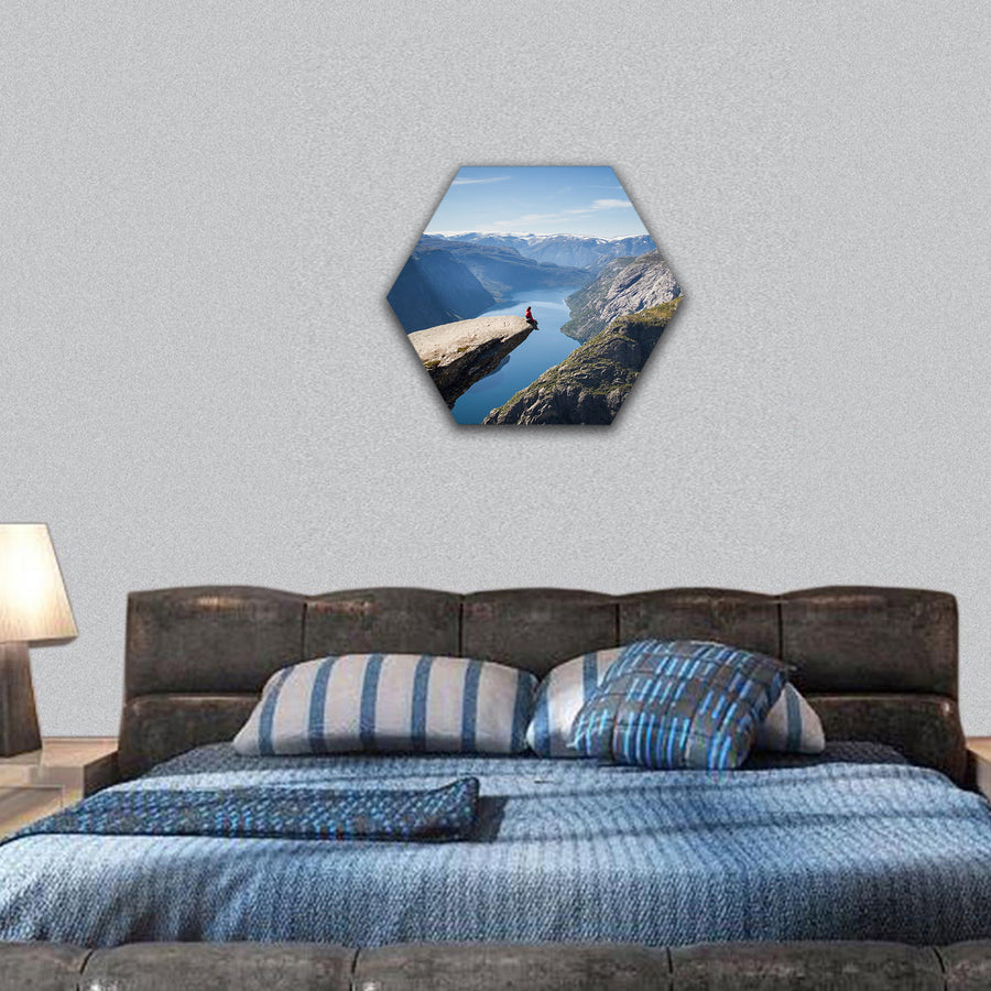 man sitting on trolltunga in Norway hexagonal canvas wall art