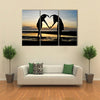 Two girls make heart with sea and sun down background multi panel canvas wall art