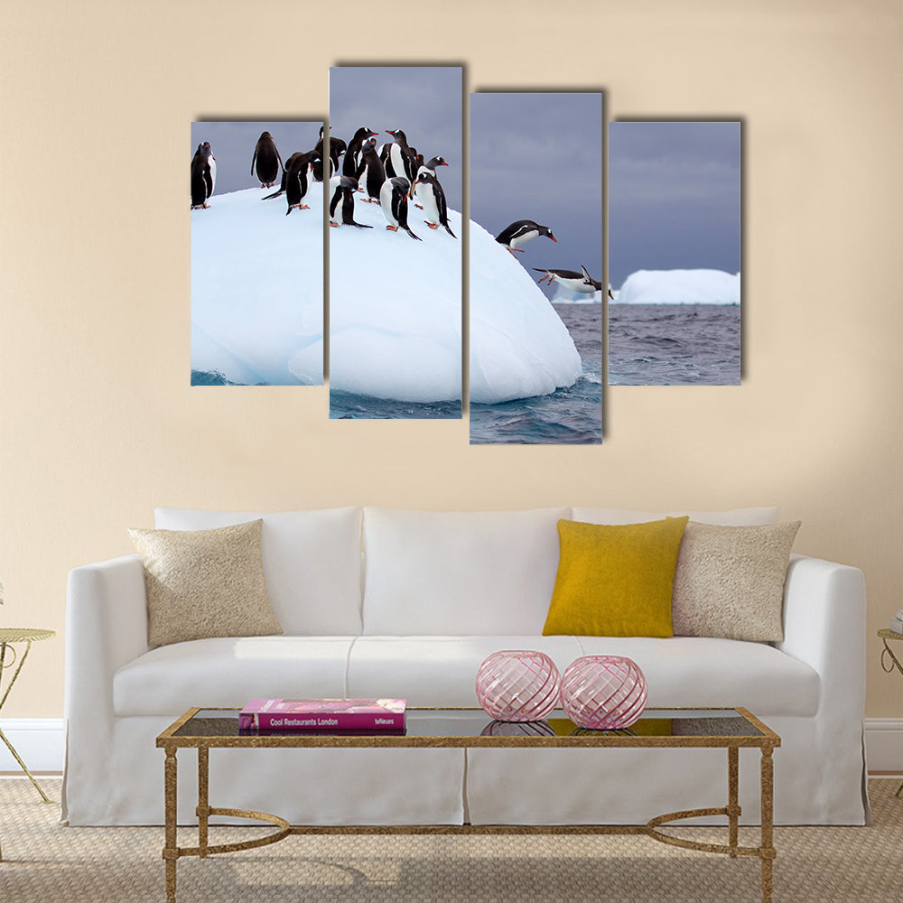 Gentoo penguin jumping into water from iceberg multi Panel Canvas wall Art