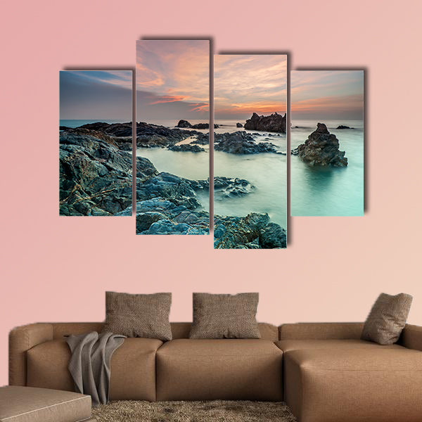 Coloring sky during sunrise with rocks on the beach wall art