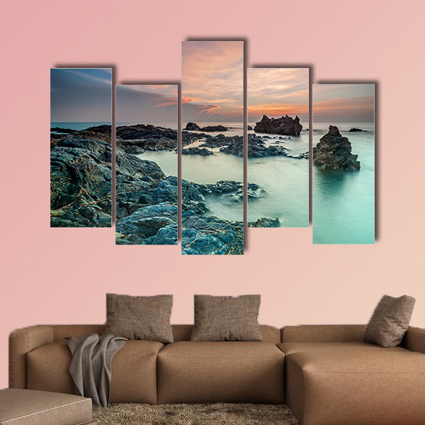 Coloring sky during sunrise with rocks on the beach wall art