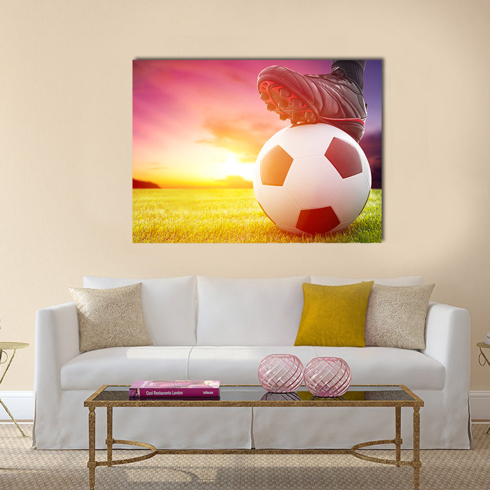 Football or soccer ball at the kickoff of a game with sunset Multi panel canvas wall art