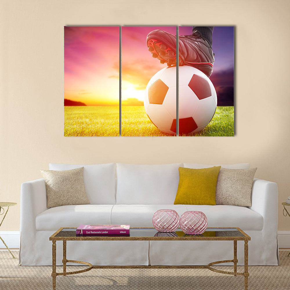 Football or soccer ball at the kickoff of a game with sunset Multi panel canvas wall art