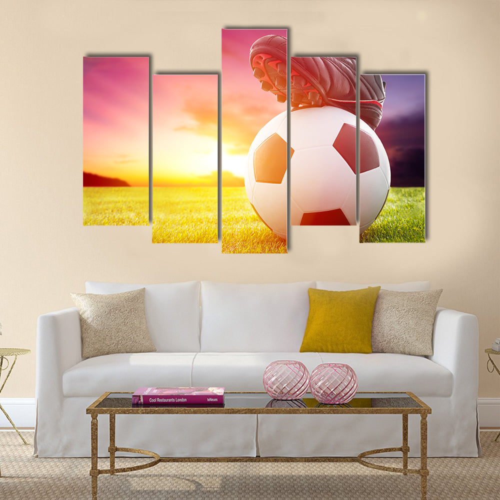 Football or soccer ball at the kickoff of a game with sunset Multi panel canvas wall art