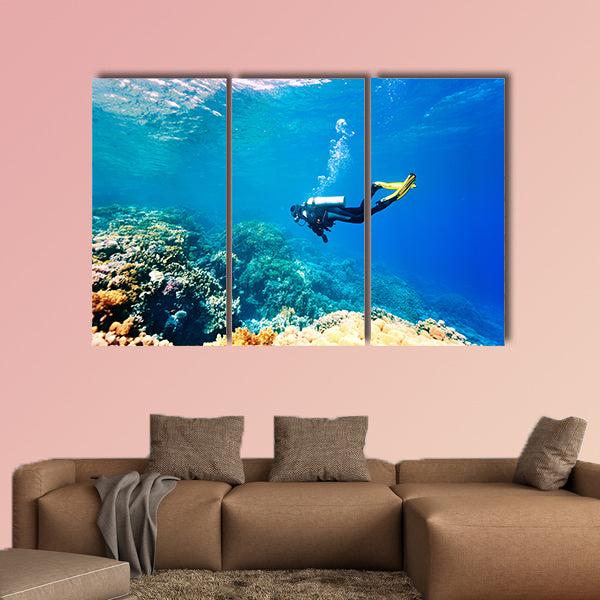Female scuba diver swimming under water Multi panel canvas wall art