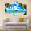 Tropical coast, beach with hang palm trees and sea, the island green and the sky Multi panel canvas wall art