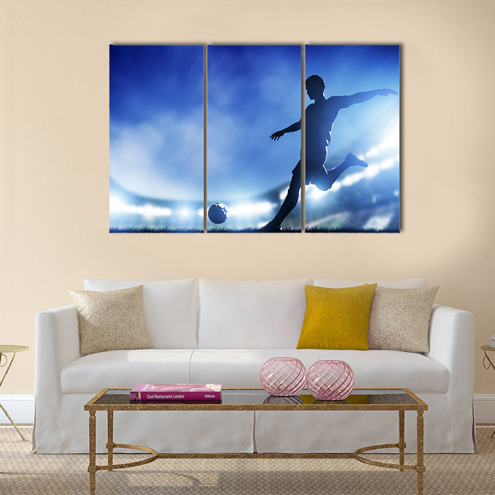 Football, soccer match A player shooting on goal Lights on the stadium at night Multi panel canvas wall art
