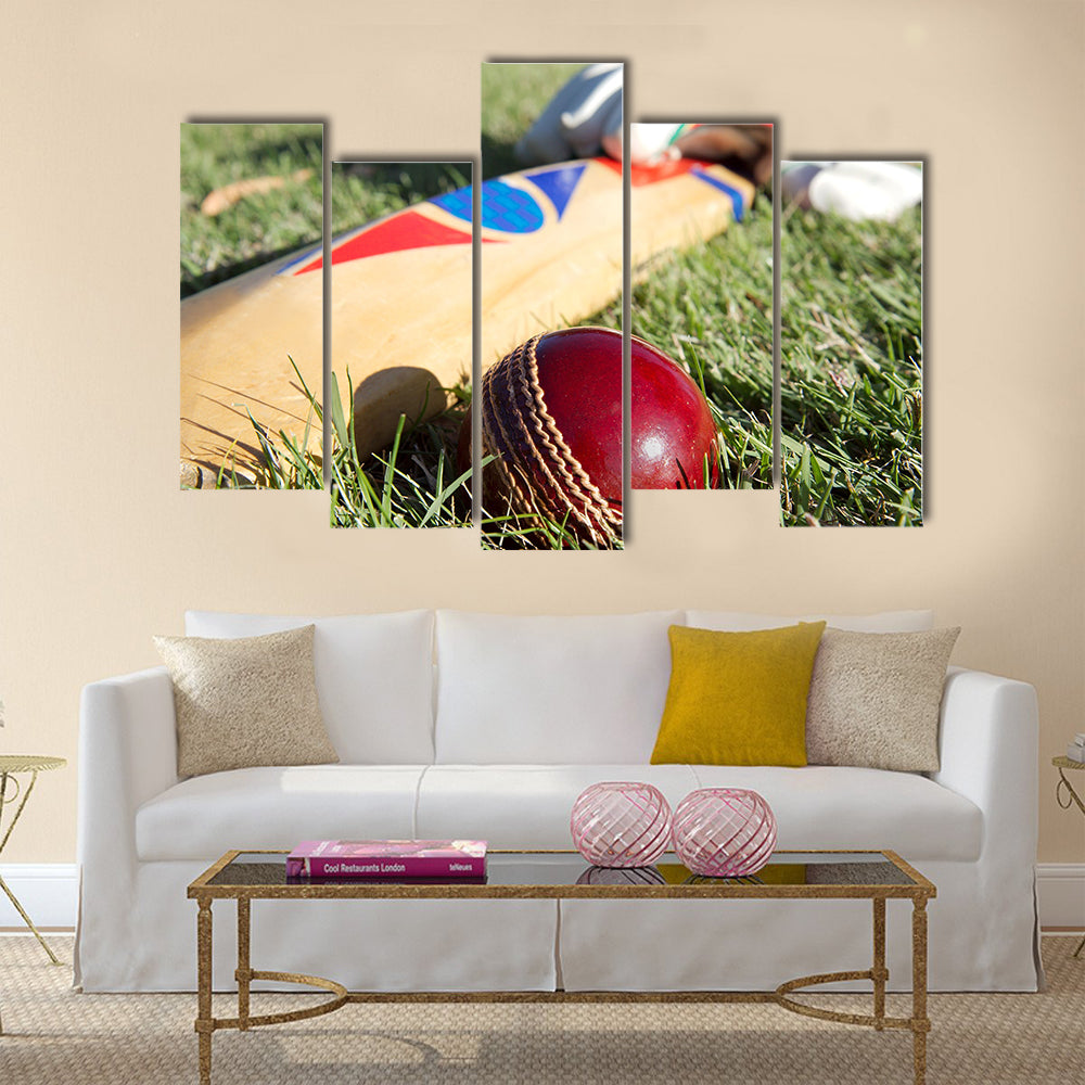 Cricket ball bat and gloves on the field Multi panel canvas Wall art