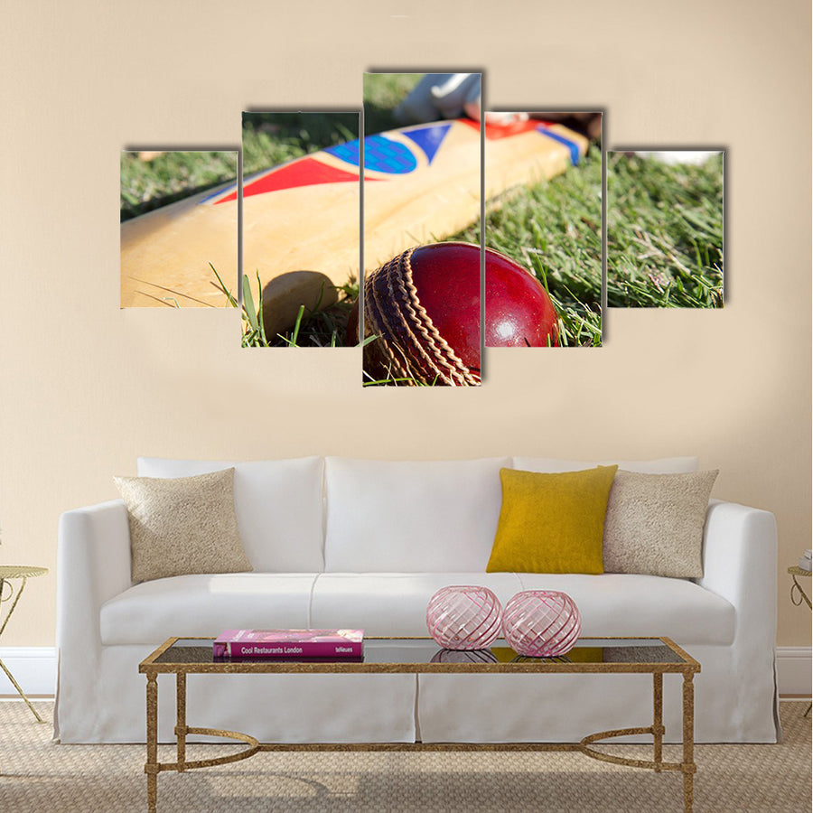 Cricket ball bat and gloves on the field Multi panel canvas Wall art