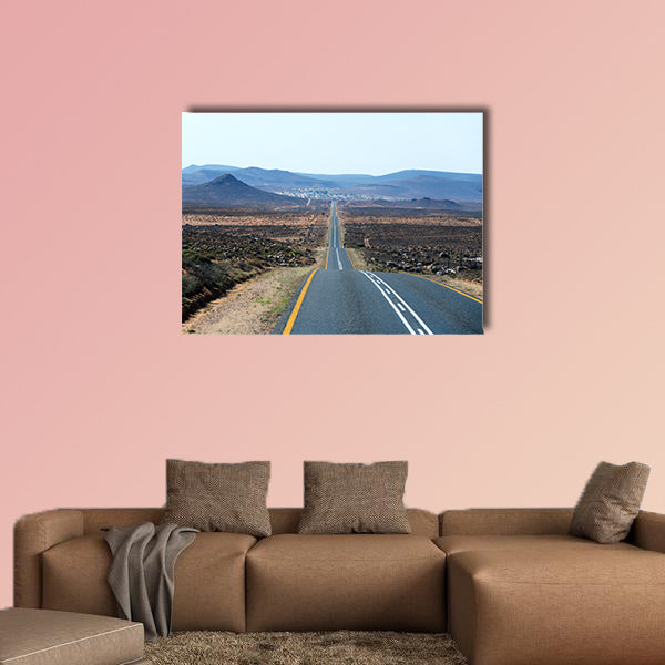 A paved road over rolling hills in a desert landscape in canvas wall art