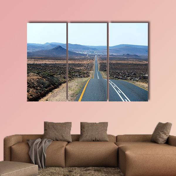 A paved road over rolling hills in a desert landscape in canvas wall art