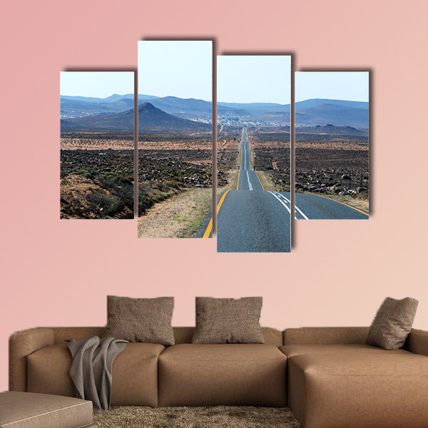 A paved road over rolling hills in a desert landscape in canvas wall art