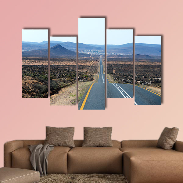 A paved road over rolling hills in a desert landscape in canvas wall art