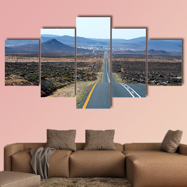 A paved road over rolling hills in a desert landscape in canvas wall art