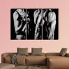 Bodybuilding strong man and a woman posing on a black background Multi panel canvas wall art