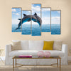 Two jumping dolphins, seascape with deep ocean waters and cloudscape Multi Panel Canvas Wall Art