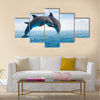 Two jumping dolphins, seascape with deep ocean waters and cloudscape Multi Panel Canvas Wall Art