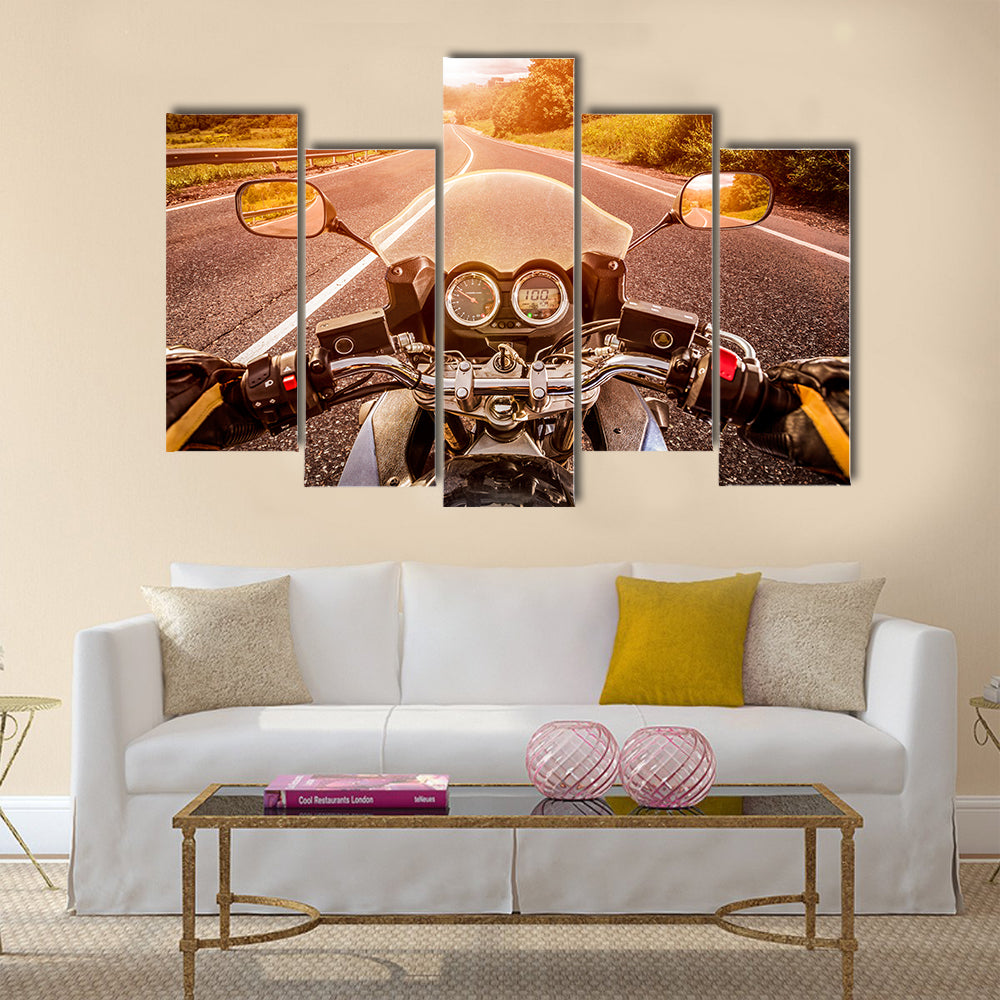 Biker driving a motorcycle rides along the asphalt road. First-person view Multi panel canvas wall art