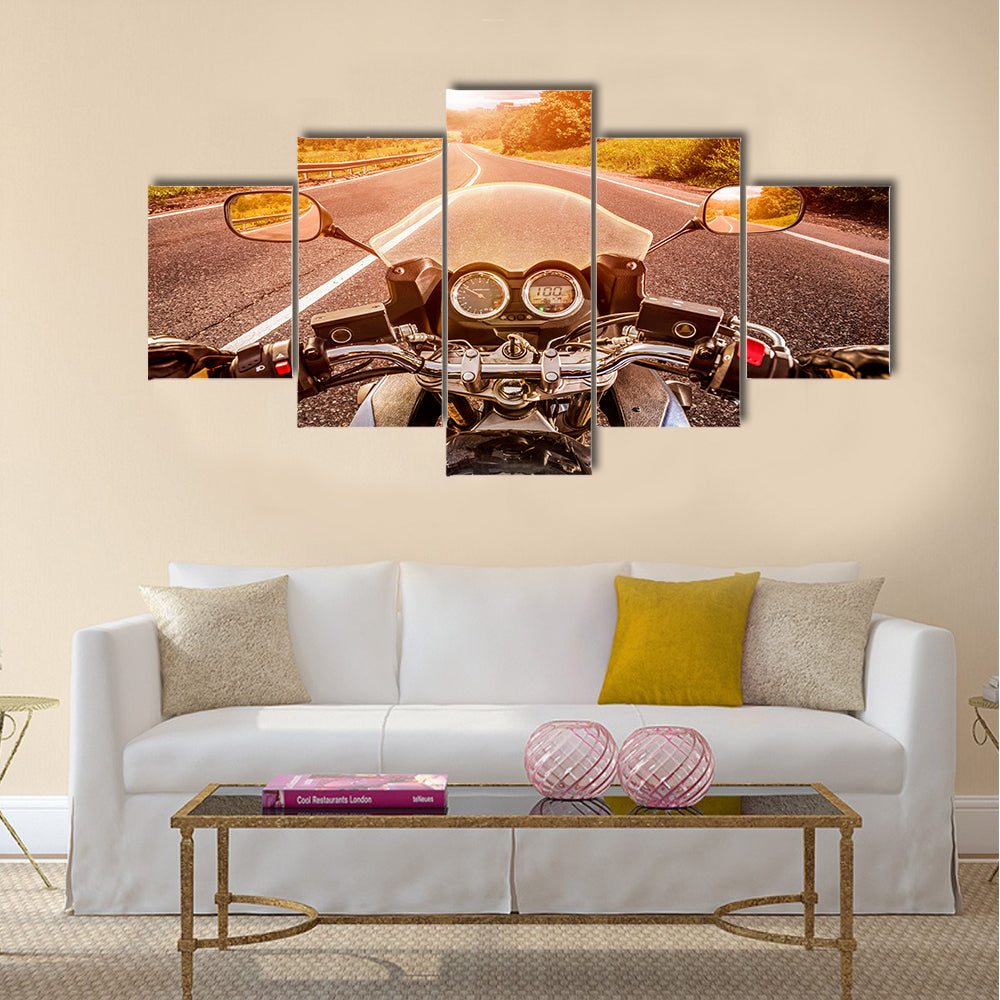 Biker driving a motorcycle rides along the asphalt road. First-person view Multi panel canvas wall art