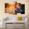 Biker driving a motorcycle rides along the asphalt road Multi panel canvas wall art