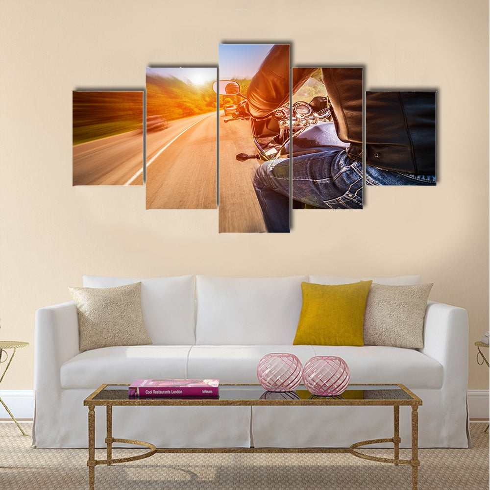 Biker driving a motorcycle rides along the asphalt road Multi panel canvas wall art