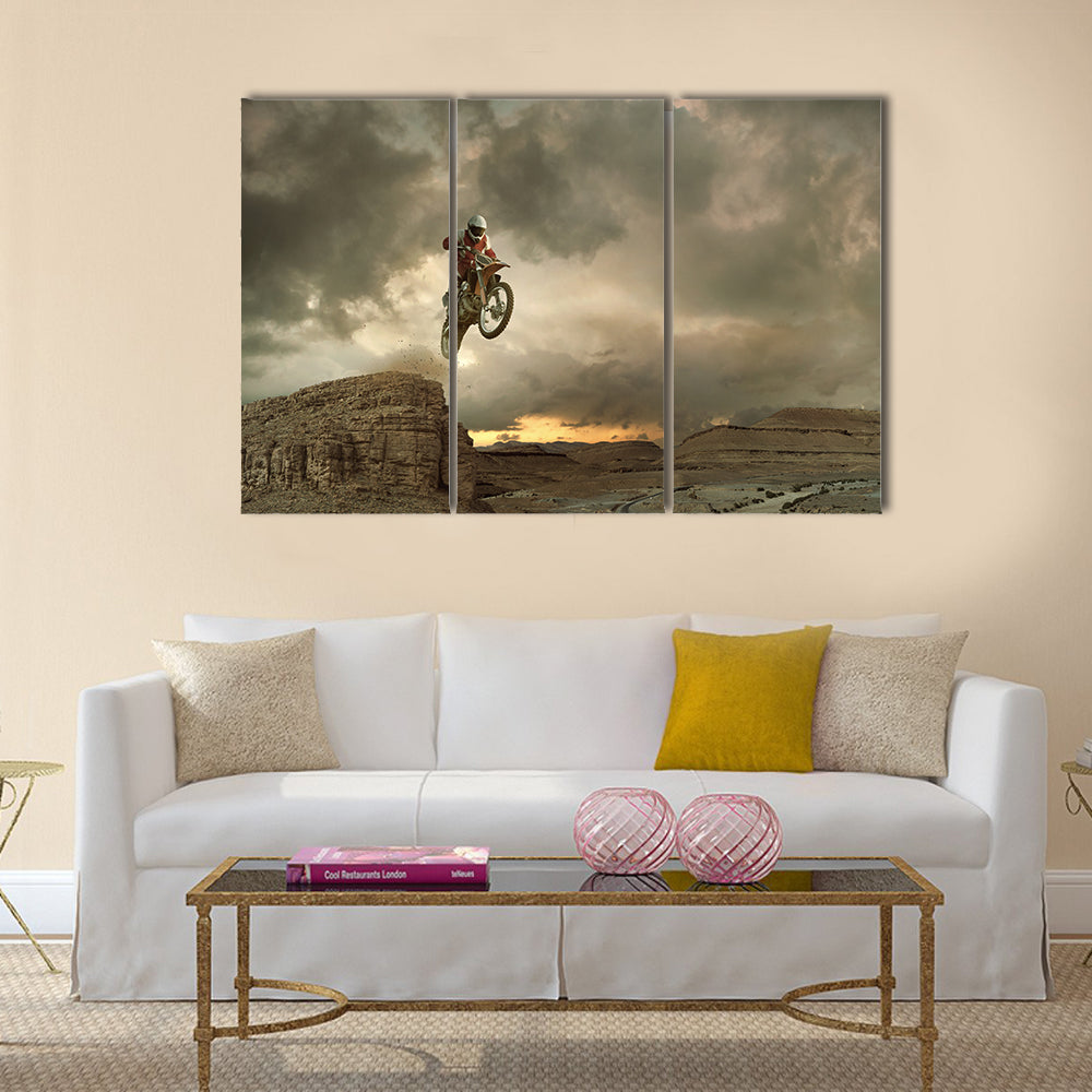 A picture of a biker making a stunt and jumps in the air Multi panel canvas wall art