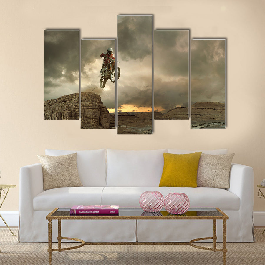 A picture of a biker making a stunt and jumps in the air Multi panel canvas wall art