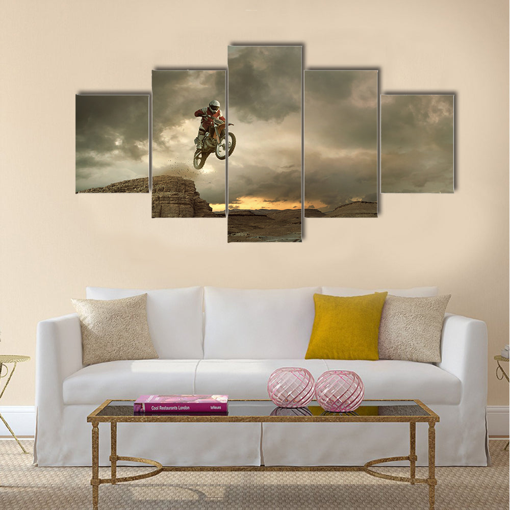 A picture of a biker making a stunt and jumps in the air Multi panel canvas wall art