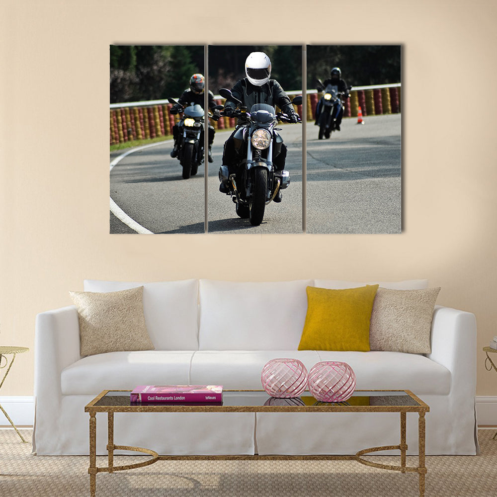 Biker on road with helmet and wet asphalt Multi panel canvas wall art